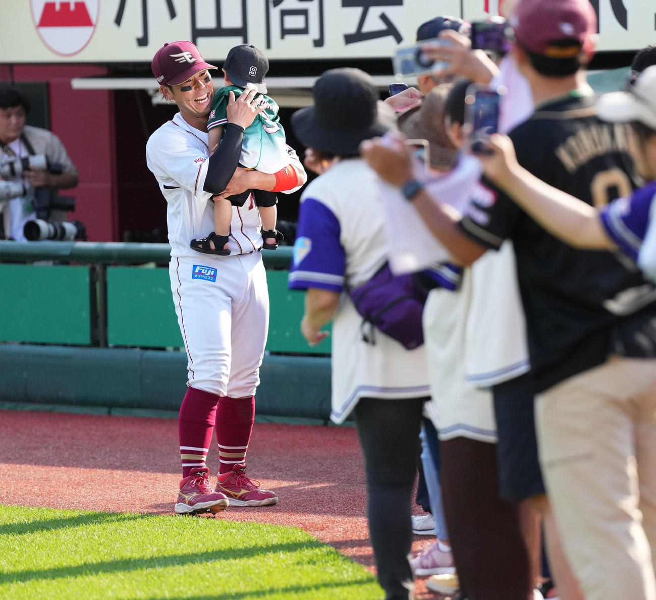 楽天対広島　広島に勝利し、ファンの子供を抱きかかえる楽天鈴木大（撮影・菅敏）