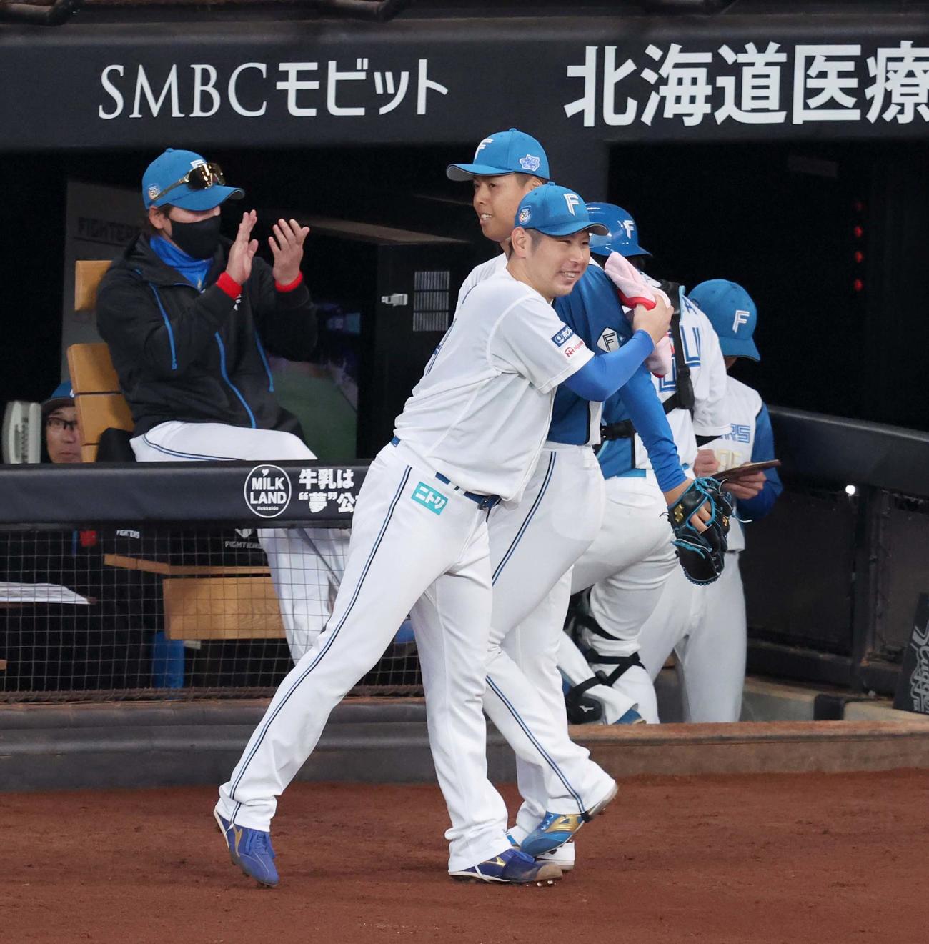 日本ハム対巨人　7回表、無失点に抑えた2番手杉浦を笑顔で出迎える加藤貴（手前）（撮影・黒川智章）