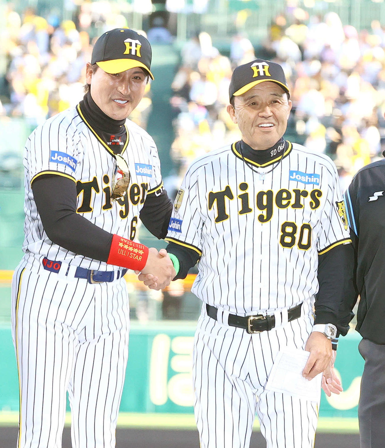5月29日、阪神対日本ハム　試合前のメンバー表交換で日本ハム新庄監督（左）は阪神のユニホームを着て阪神岡田監督と握手をかわす