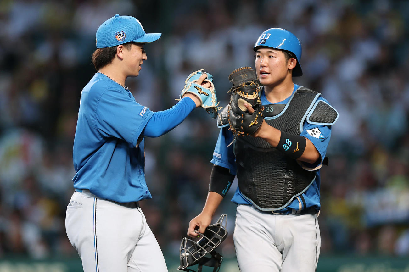 阪神対日本ハム　4回裏阪神2死一塁、佐藤輝を左飛に仕留めタッチを交わす細野（左）と進藤（撮影・前田充）