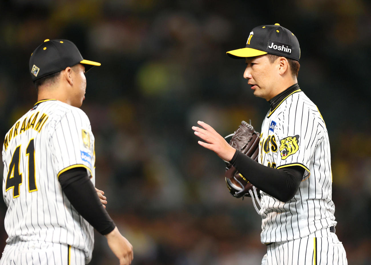 阪神対日本ハム　9回表を抑えた阪神岩崎（右）を出迎える村上（撮影・上山淳一）