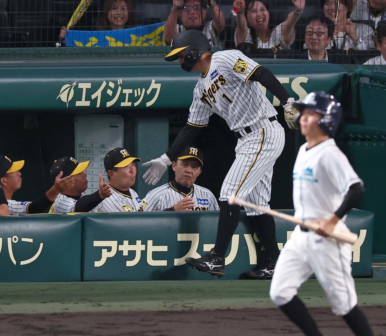阪神対日本ハム　5回裏阪神2死満塁、岡田監督（右から2人目）は近本の先制適時打で生還した森下を出迎える（撮影・上田博志）