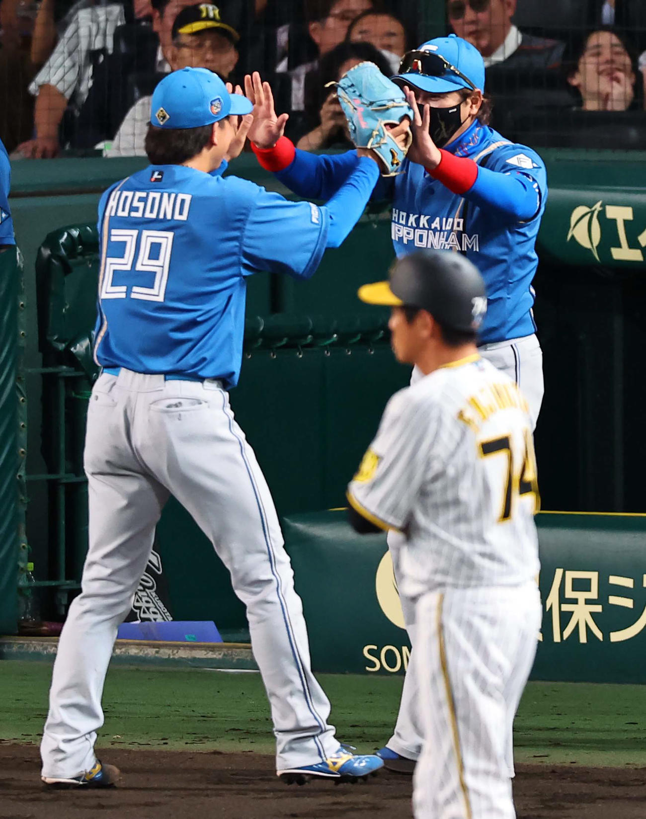 18日、降板する細野（左）をハイタッチで出迎える新庄監督