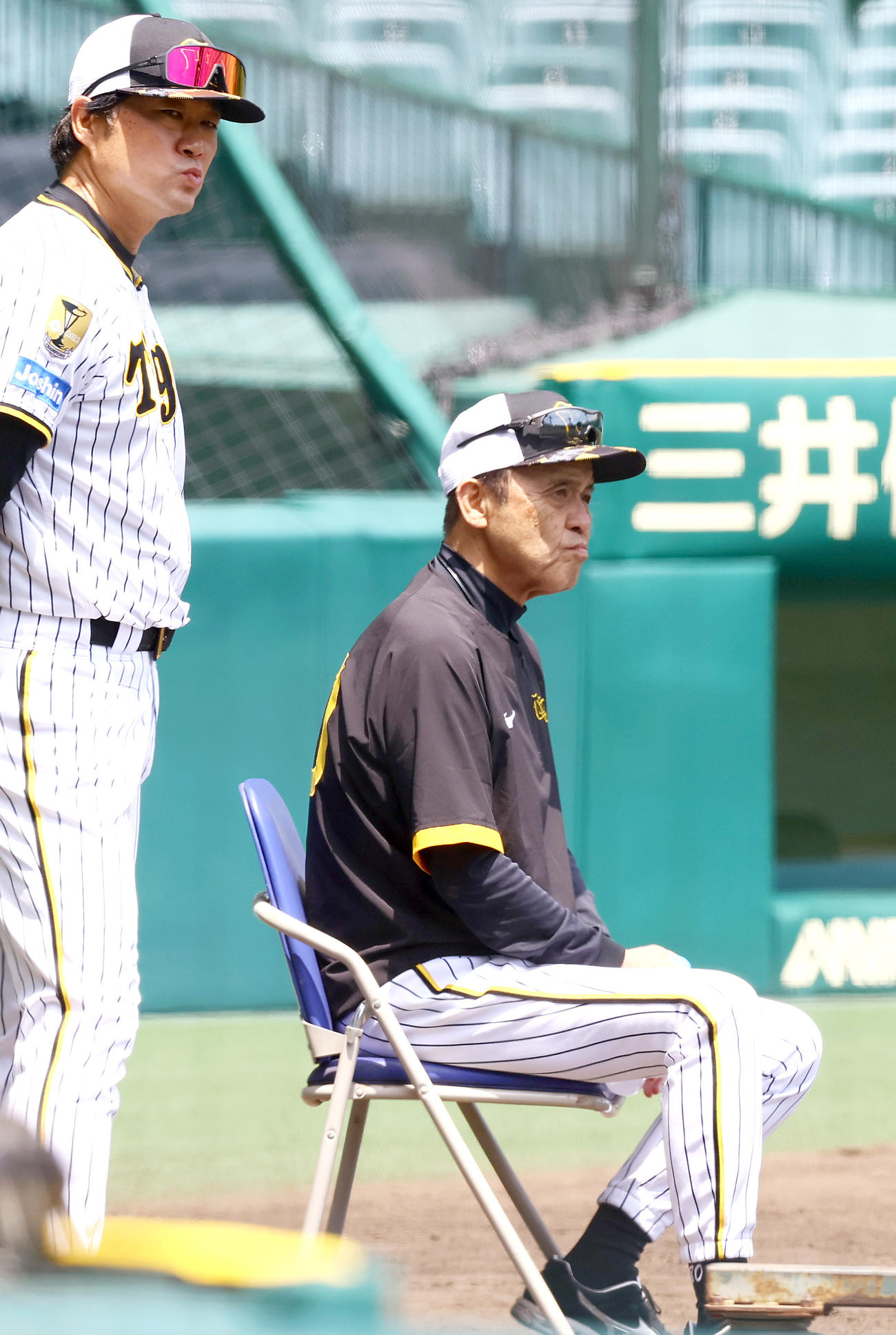 岡田監督（右）は厳しい表情でケース打撃を確認する。左は安藤投手コーチ（撮影・上山淳一）