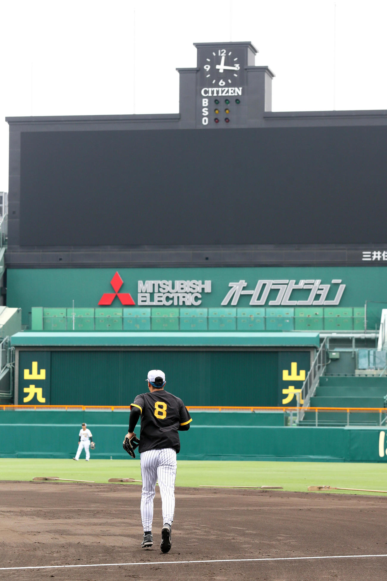 グラブをつけ甲子園球場のグラウンドに駆けだす阪神佐藤輝（撮影・上山淳一）