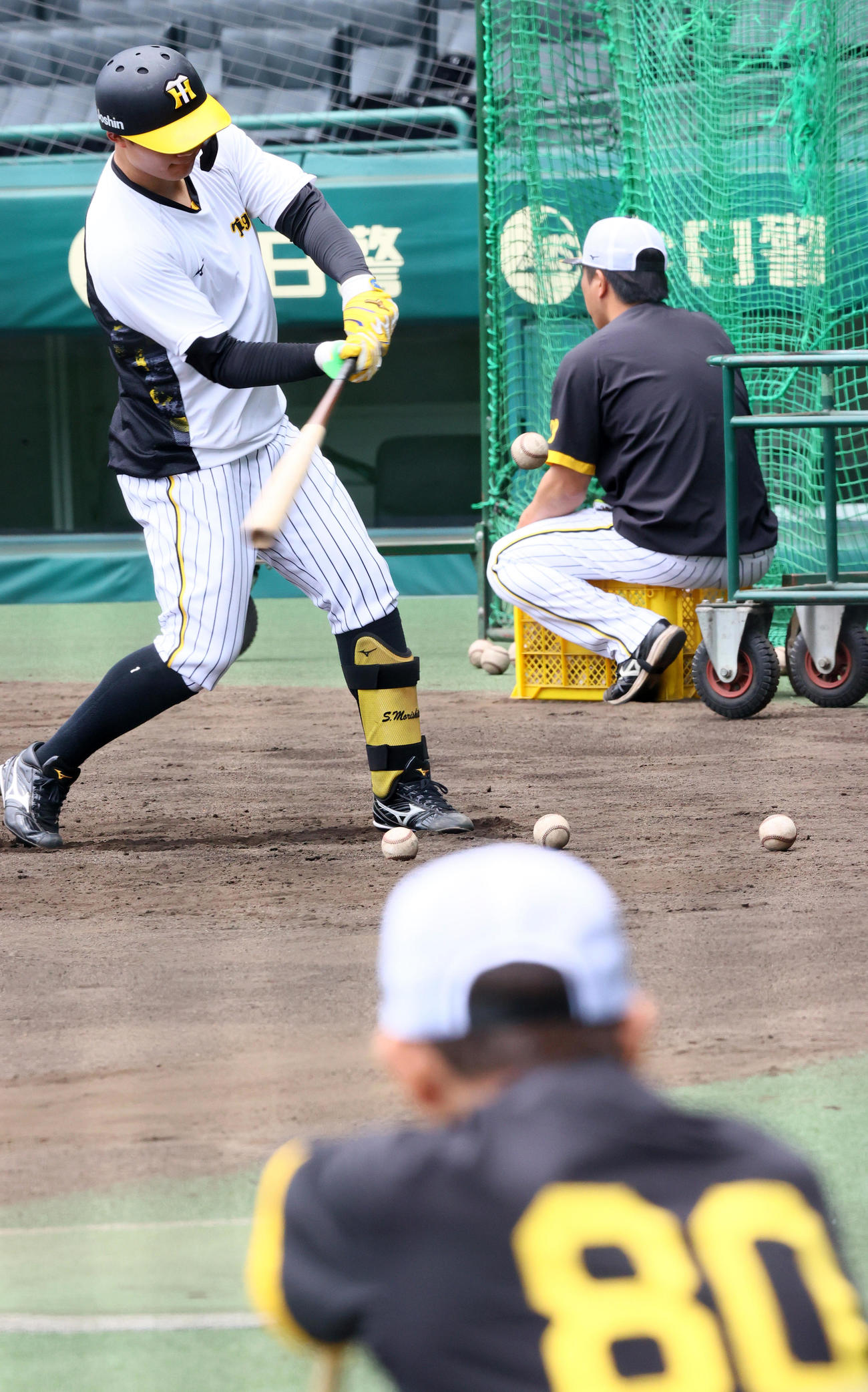 阪神岡田監督（手前）はトス打撃する阪神森下を見つめる（撮影・上山淳一）