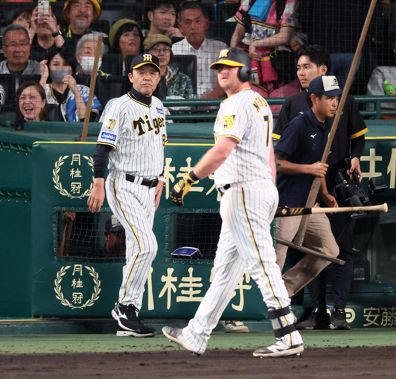 阪神対DeNA 7回裏を終え選手交代を告げる岡田監督。右は一邪飛を打ち上げベンチへ引き揚げる代打ノイジー（撮影・加藤哉）