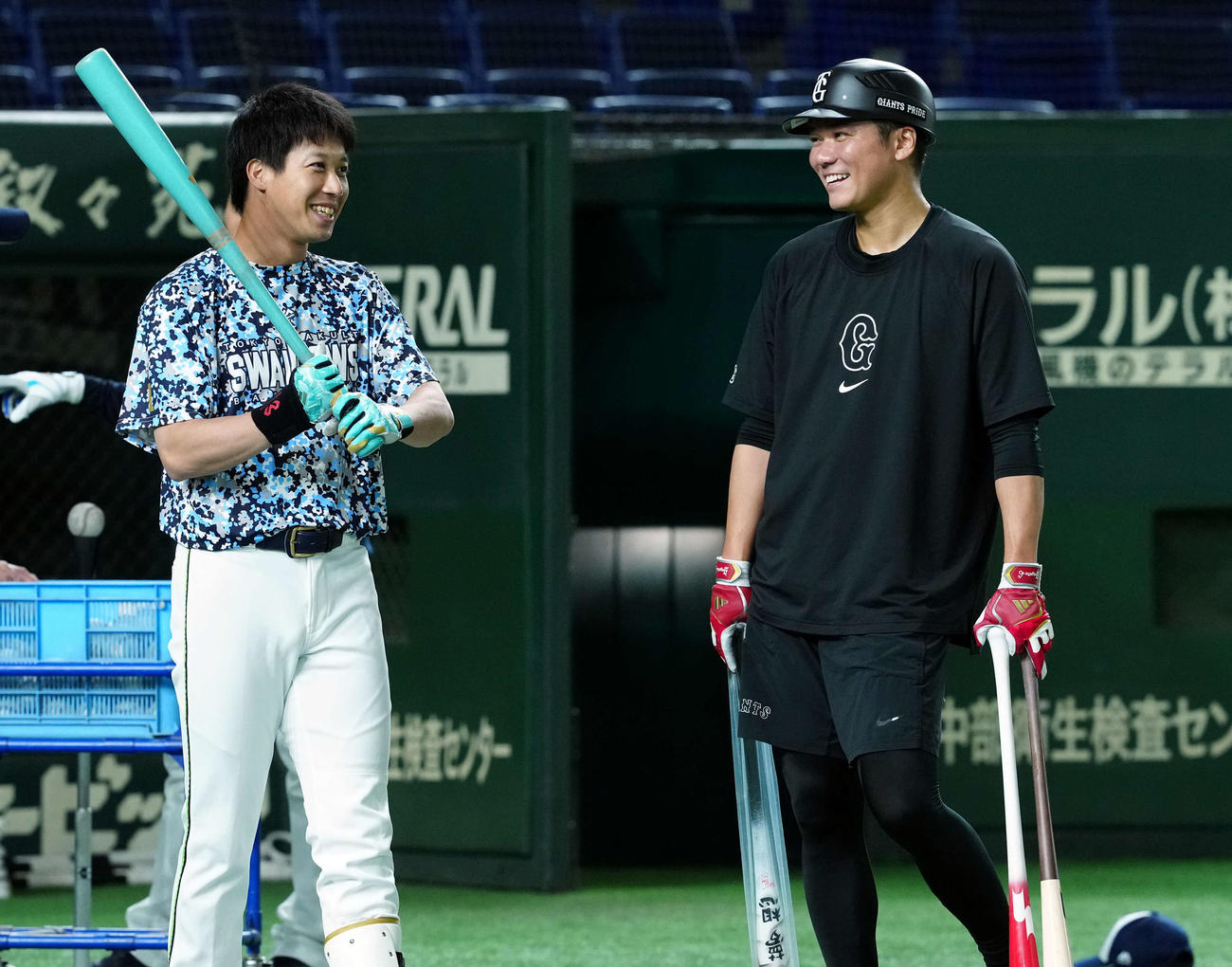 巨人対ヤクルト　試合前練習で水色のバットを手にした田ヤクルト山田（左）と言葉をかわす巨人坂本（撮影・たえ見朱実）