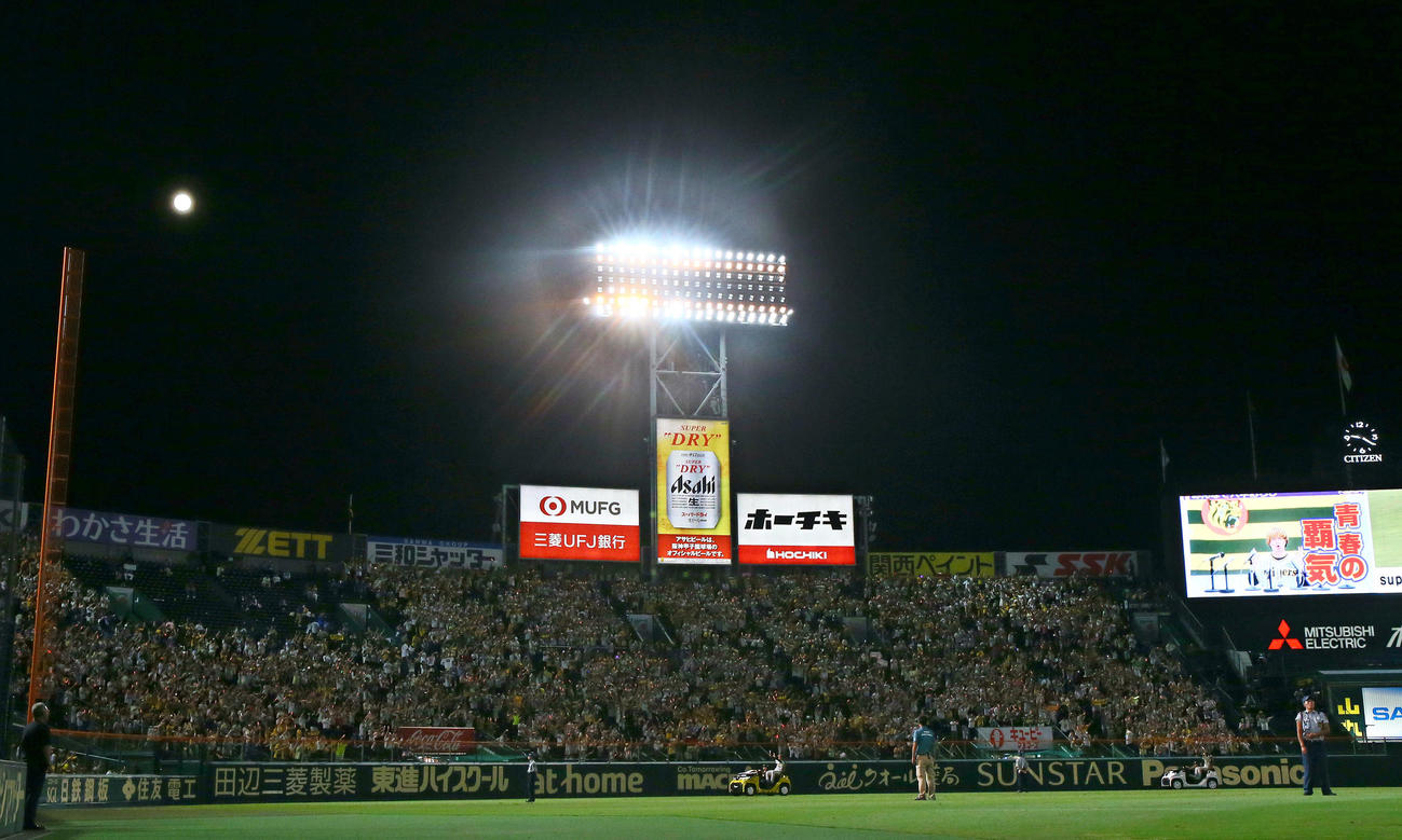 阪神対DeNA　甲子園の夜空に浮かぶ満月の下、リリーフカーで場内一周するヒーローの石井と小幡（撮影・上山淳一）
