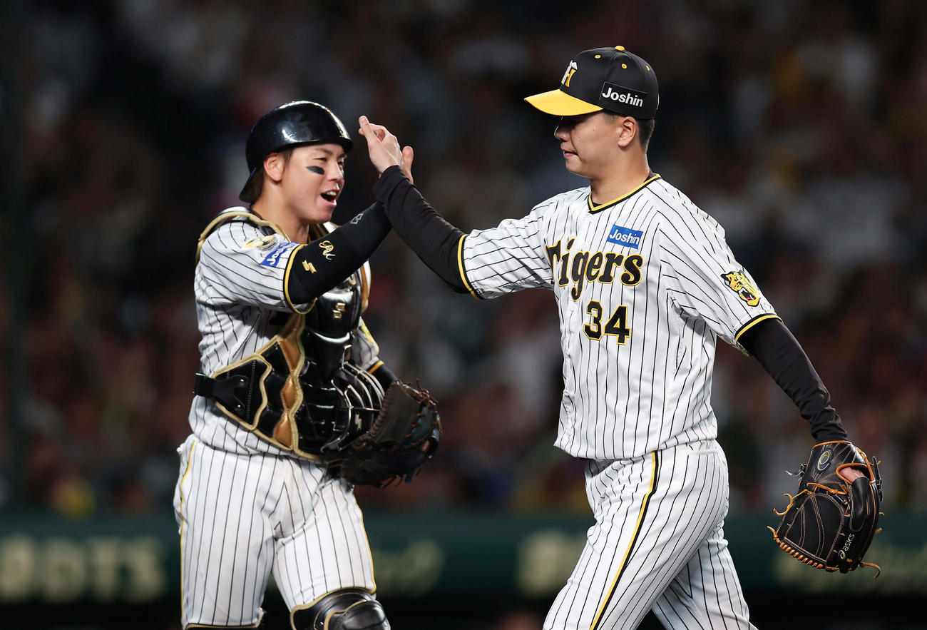 阪神対DeNA 8回表DeNA1死一、二塁、オースティンを三ゴロ併殺に仕留め、タッチを交わす梅野（左）と漆原（撮影・前田充）
