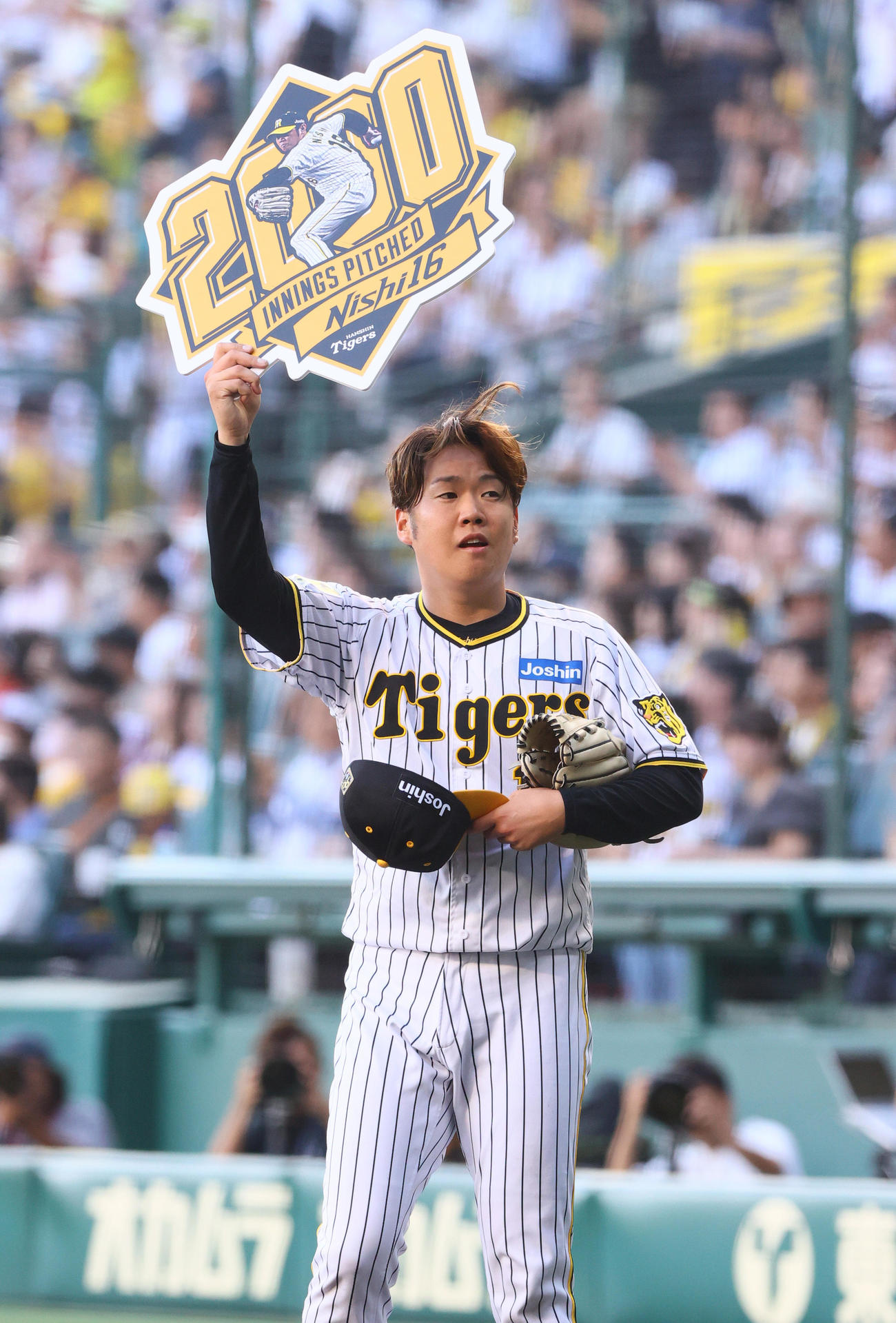 2024年6月21日、阪神対DeNA　阪神西勇は通算2000投球回を達成し記念ボードを手にファンの声援に応える（撮影・上山淳一）