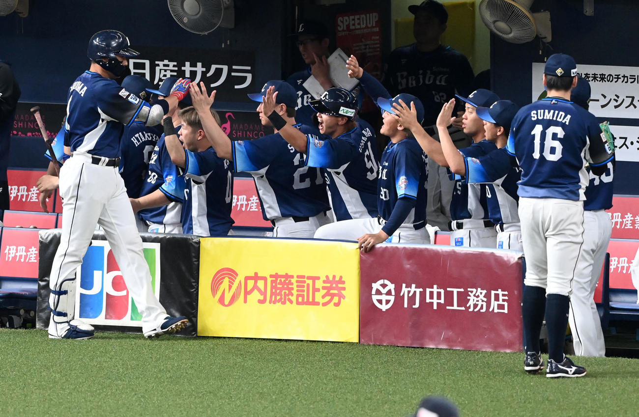 オリックス対西武　1回表西武1死三塁、先制右犠飛を放った栗山（左）を笑顔で迎える西武ナイン（撮影・前岡正明）