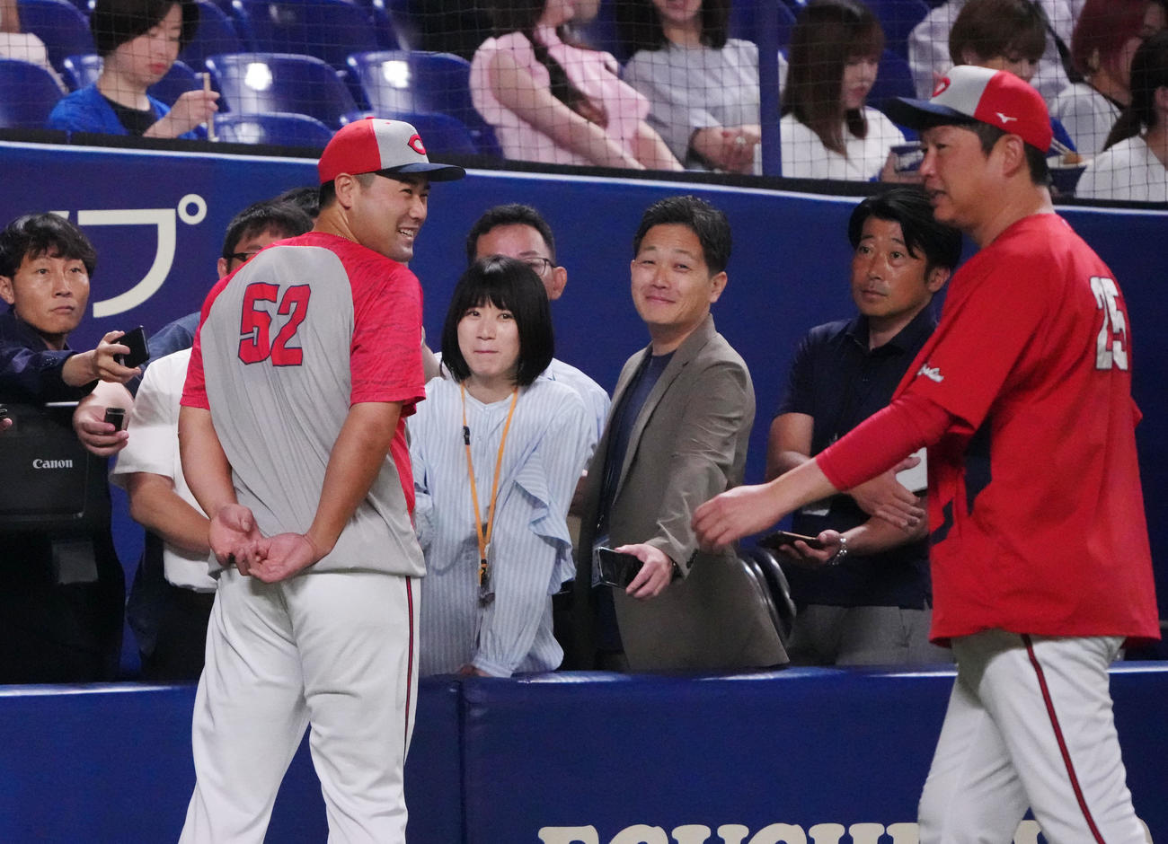 中日対広島　試合前、取材対応中に新井監督からいじられる末包（手前・左）（撮影・森本幸一）