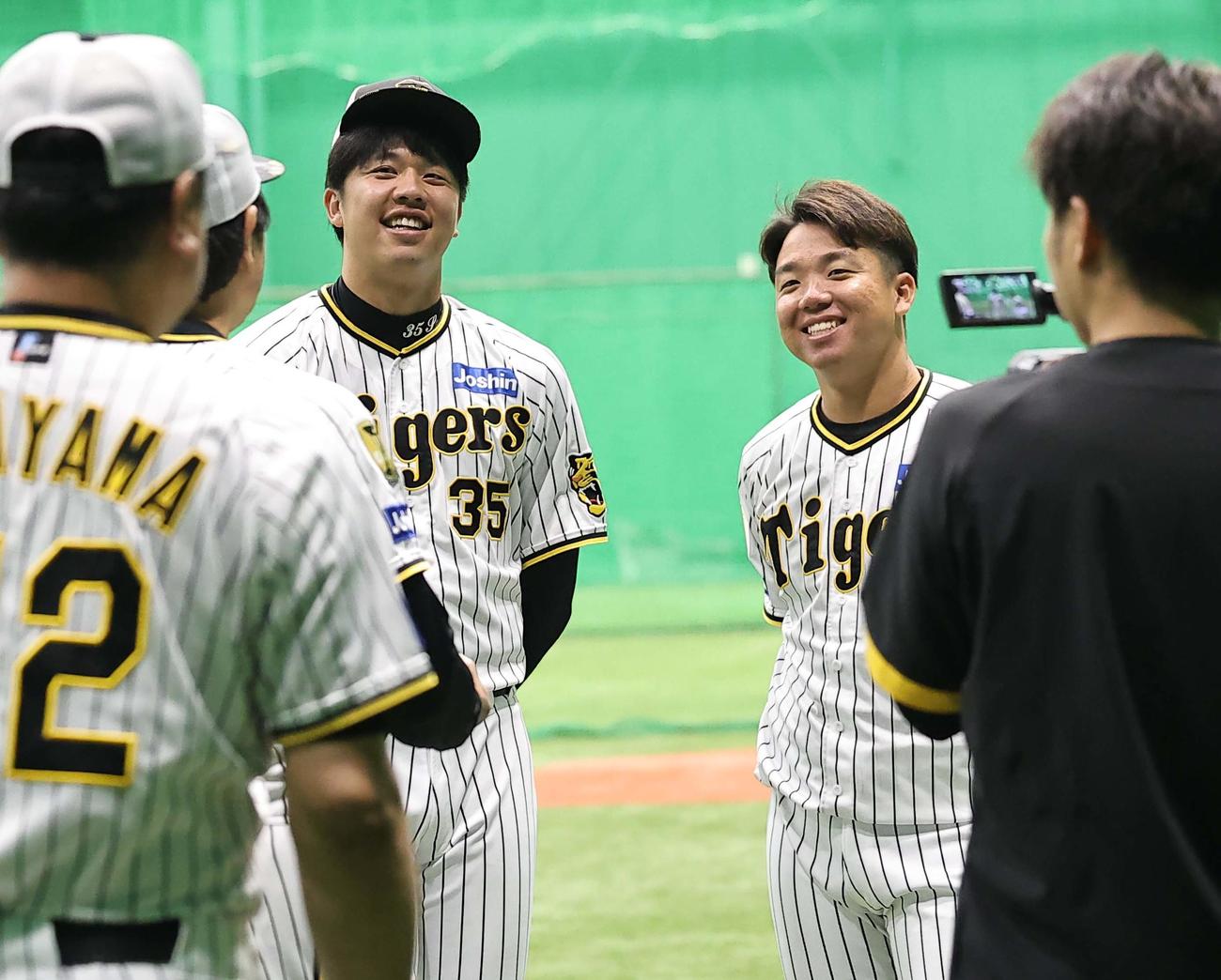 投手円陣で笑顔を見せる才木（左）と村上（撮影・上田博志）