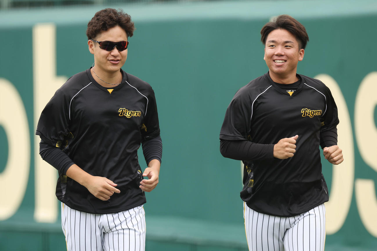 笑顔を見せながらウオーミングアップする阪神大竹（左）と村上（撮影・前田充）