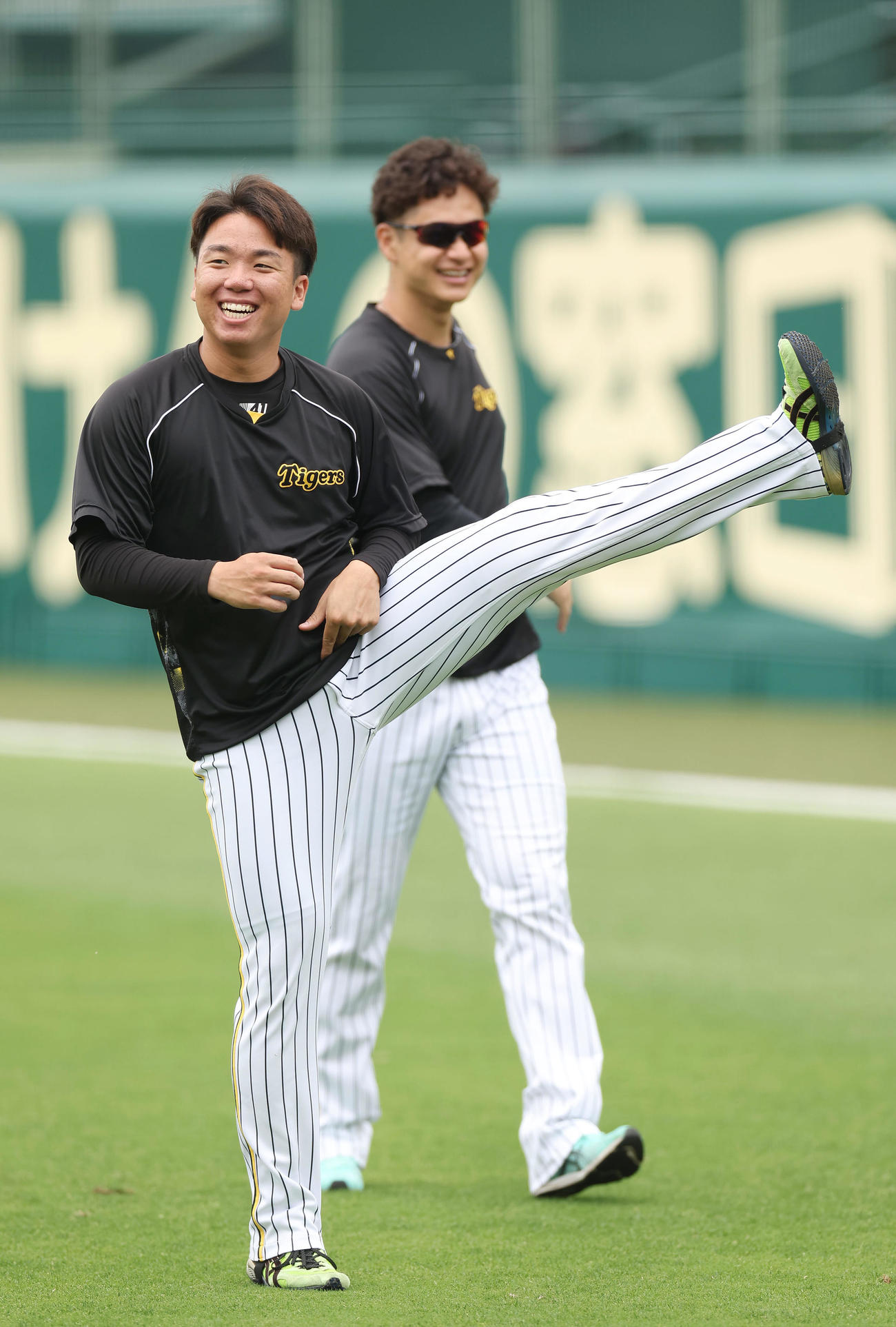 笑顔を見せながらウオーミングアップする阪神村上（手前）と大竹（撮影・前田充）