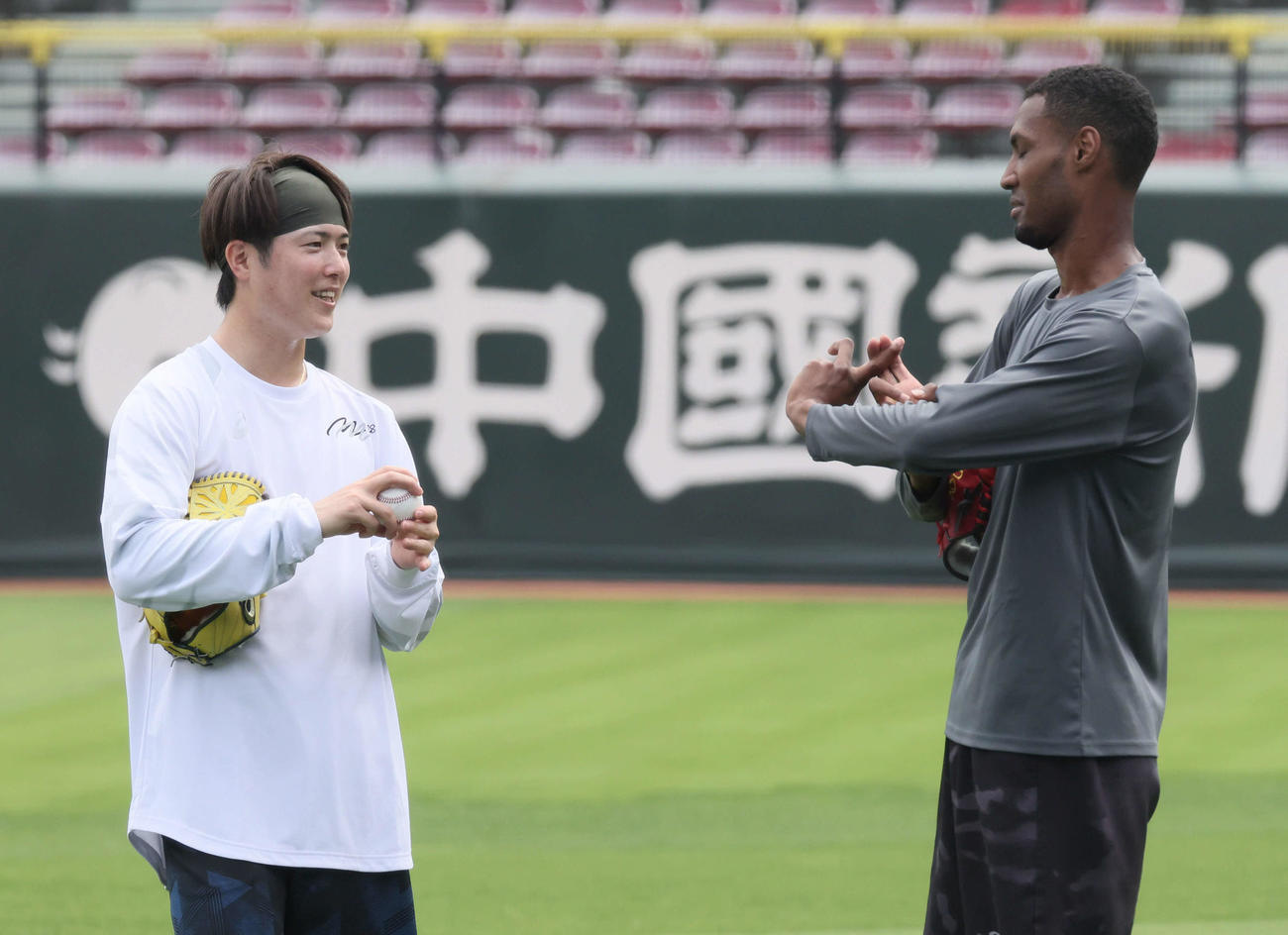 投手指名練習中、ボールの握りについて話し合う広島森下（左）とアドゥワ（撮影・加藤孝規）