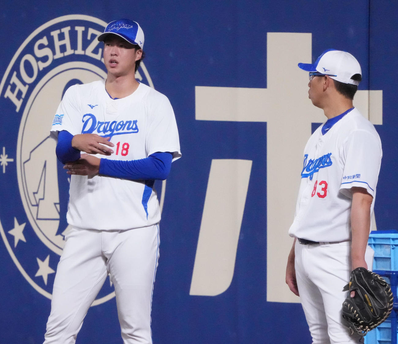 山井投手コーチと言葉を交わす梅津（左）（撮影・森本幸一）