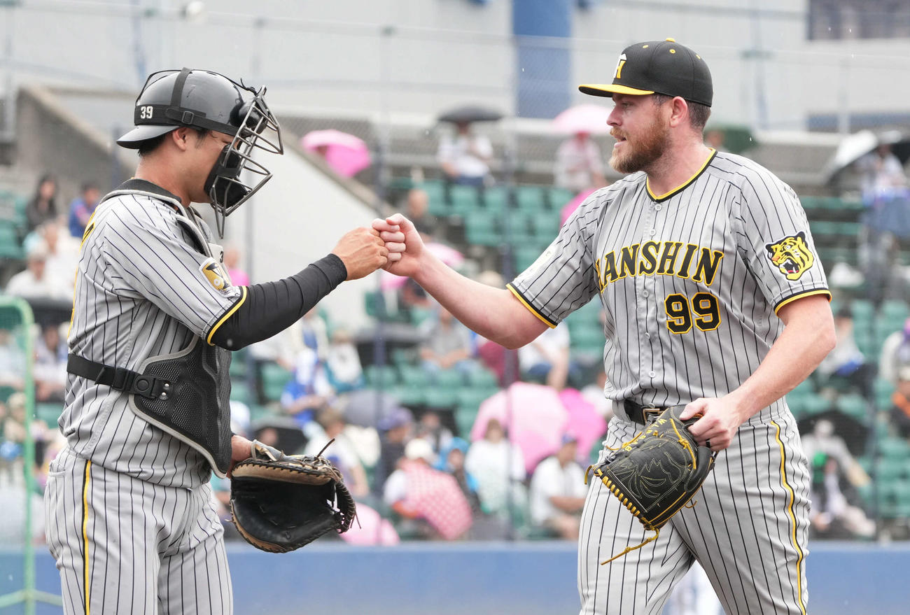 ウエスタン中日対阪神　2イニングを無失点とし、栄枝とタッチを交わしベンチへ戻るビーズリー（右）（撮影・森本幸一）