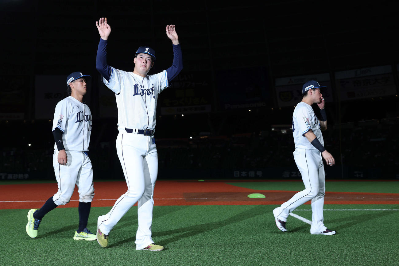 西武対日本ハム　日本ハムに勝利し、観客席にあいさつしながら引き揚げる西武の、左から牧野、渡辺、岸（撮影・河田真司）