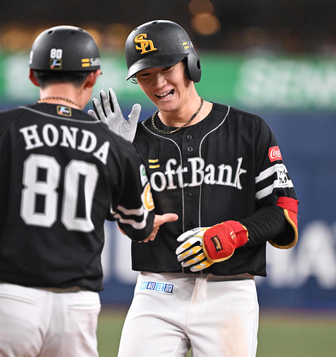 オリックス対ソフトバンク　8回表ソフトバンク1死一、二塁、中前適時打を放った正木は笑顔で本多コーチとタッチ（撮影・和賀正仁）