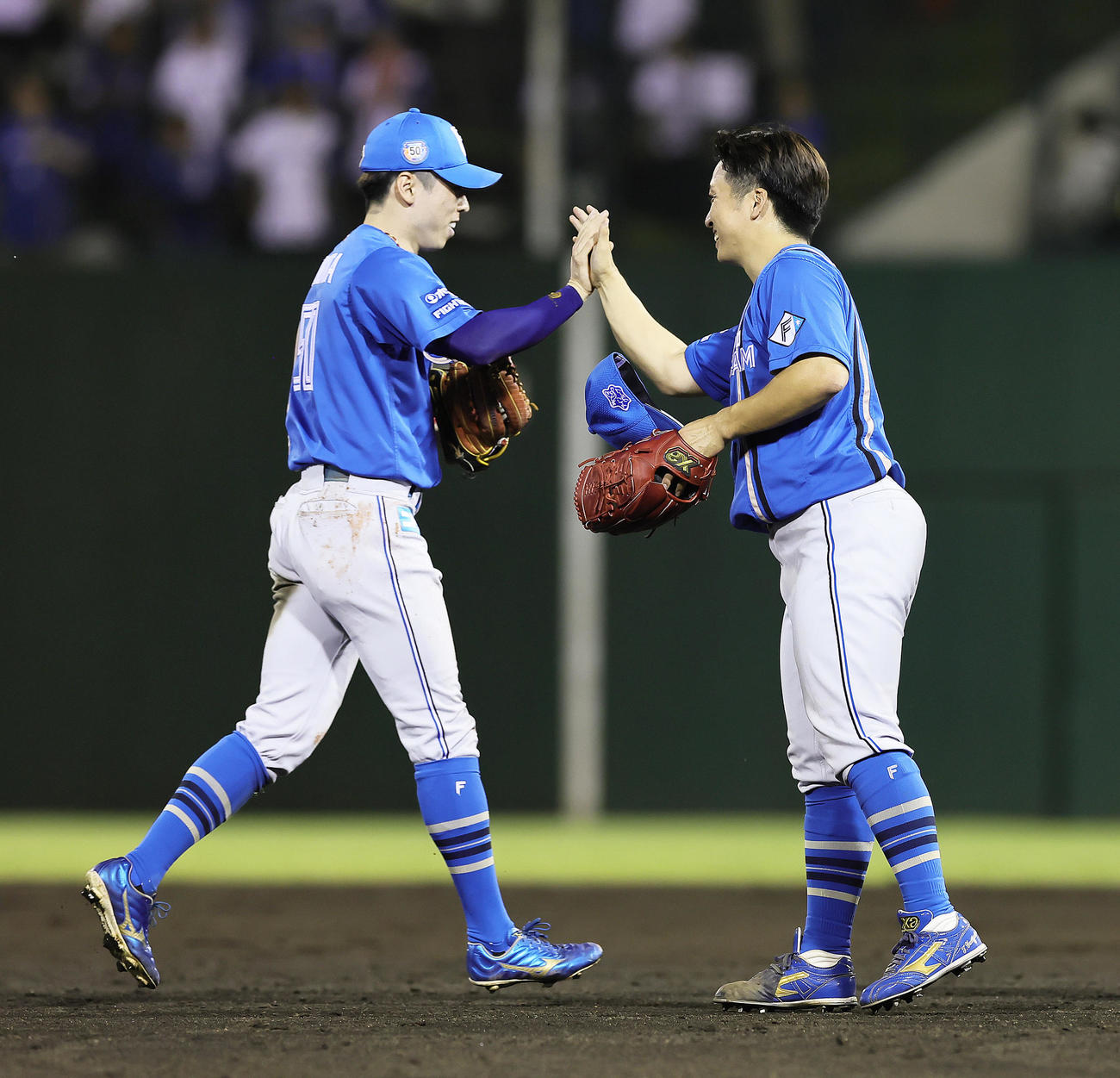 西武対日本ハム　12回裏西武2死一、二塁、松原聖弥の打球を好捕し左飛とした五十幡（左）は山本拓とタッチを交わす（撮影・足立雅史）