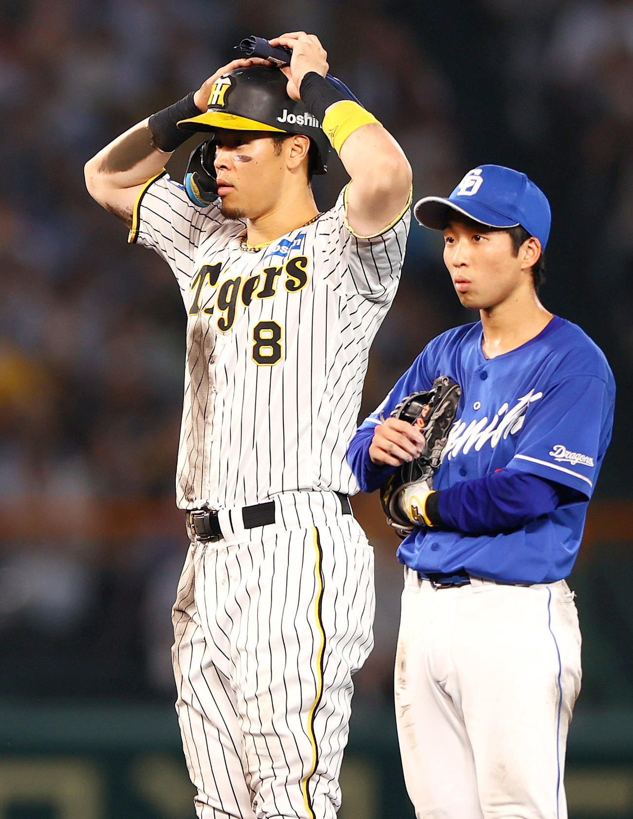 阪神対中日　5回裏阪神1死、リクエストも判定が変わらずアウトとなり頭を抱える佐藤輝。右は二塁手田中（撮影・上山淳一）