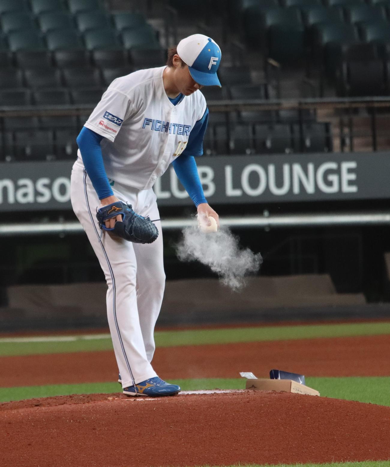 ロジンをつけ投球練習に臨む日本ハム山崎（撮影・永野高輔）