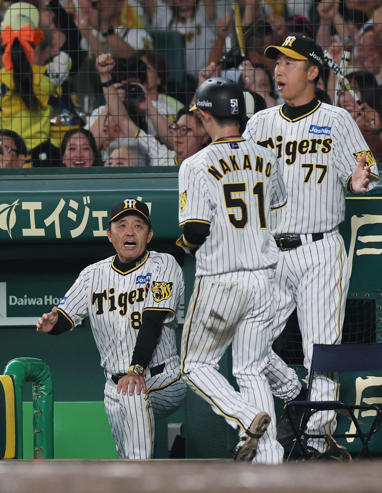 阪神対中日　7回裏阪神無死一、三塁、大山の適時打で生還した中野（中央）を迎える岡田監督（左）（撮影・前田充）