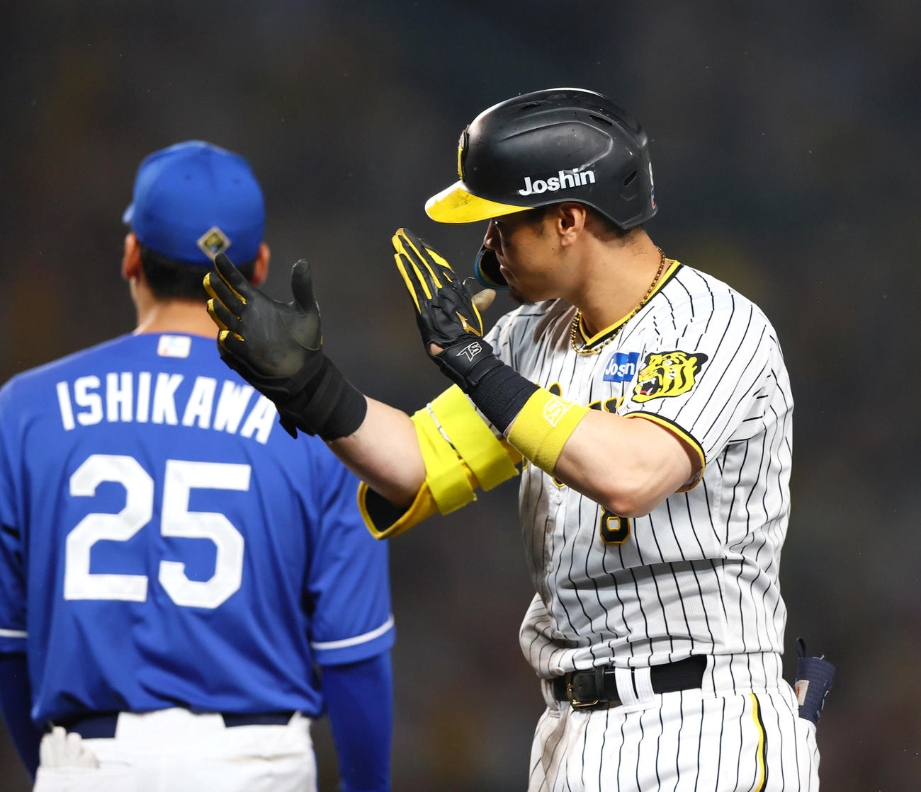 阪神対中日　7回裏阪神無死二、三塁、佐藤輝は左前2点適時打を放ち手をたたく（撮影・上山淳一）