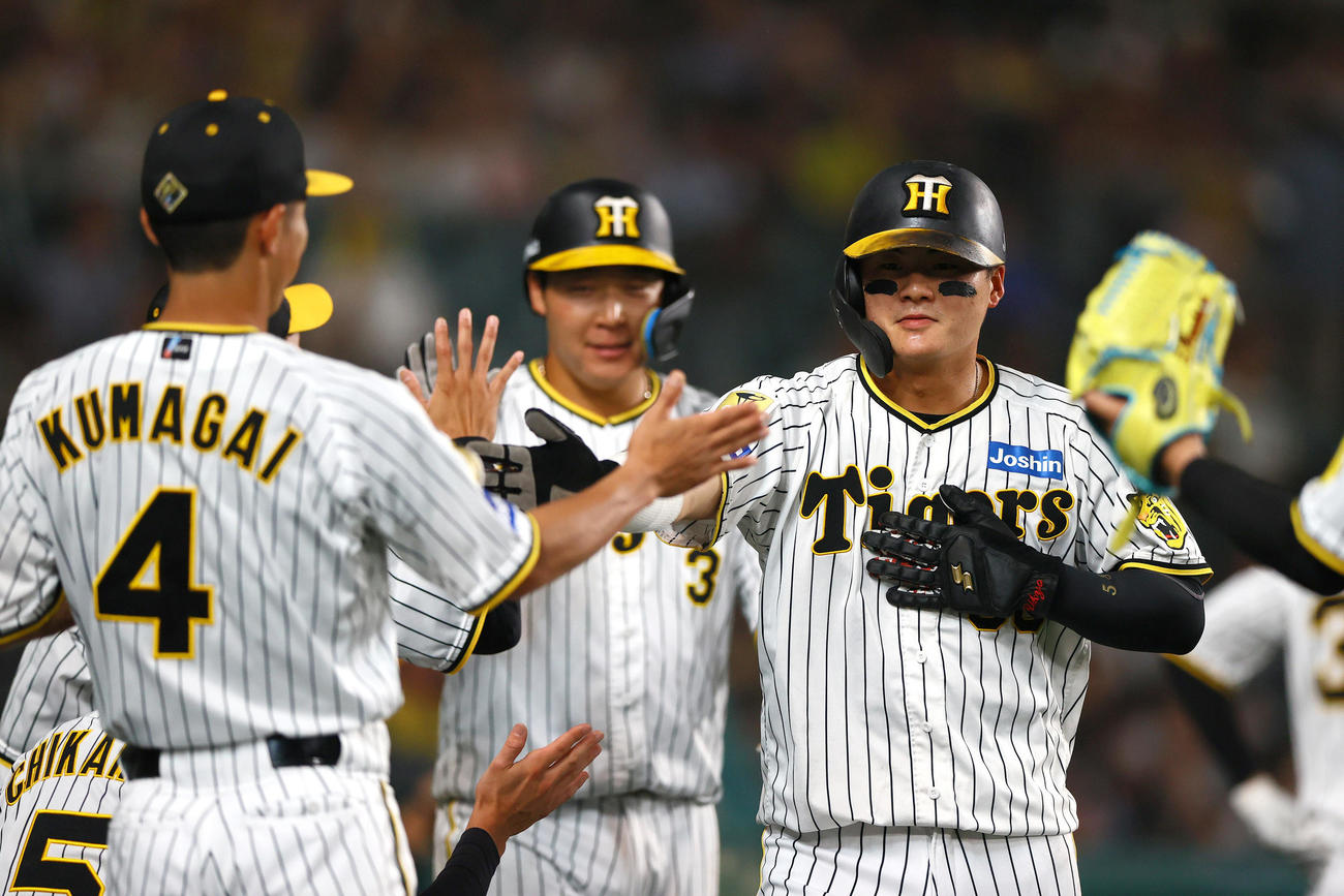 阪神対中日　7回裏阪神無死二、三塁、前川（手前）と大山は佐藤輝の左前2点適時打で生還し出迎えを受ける（撮影・上山淳一）