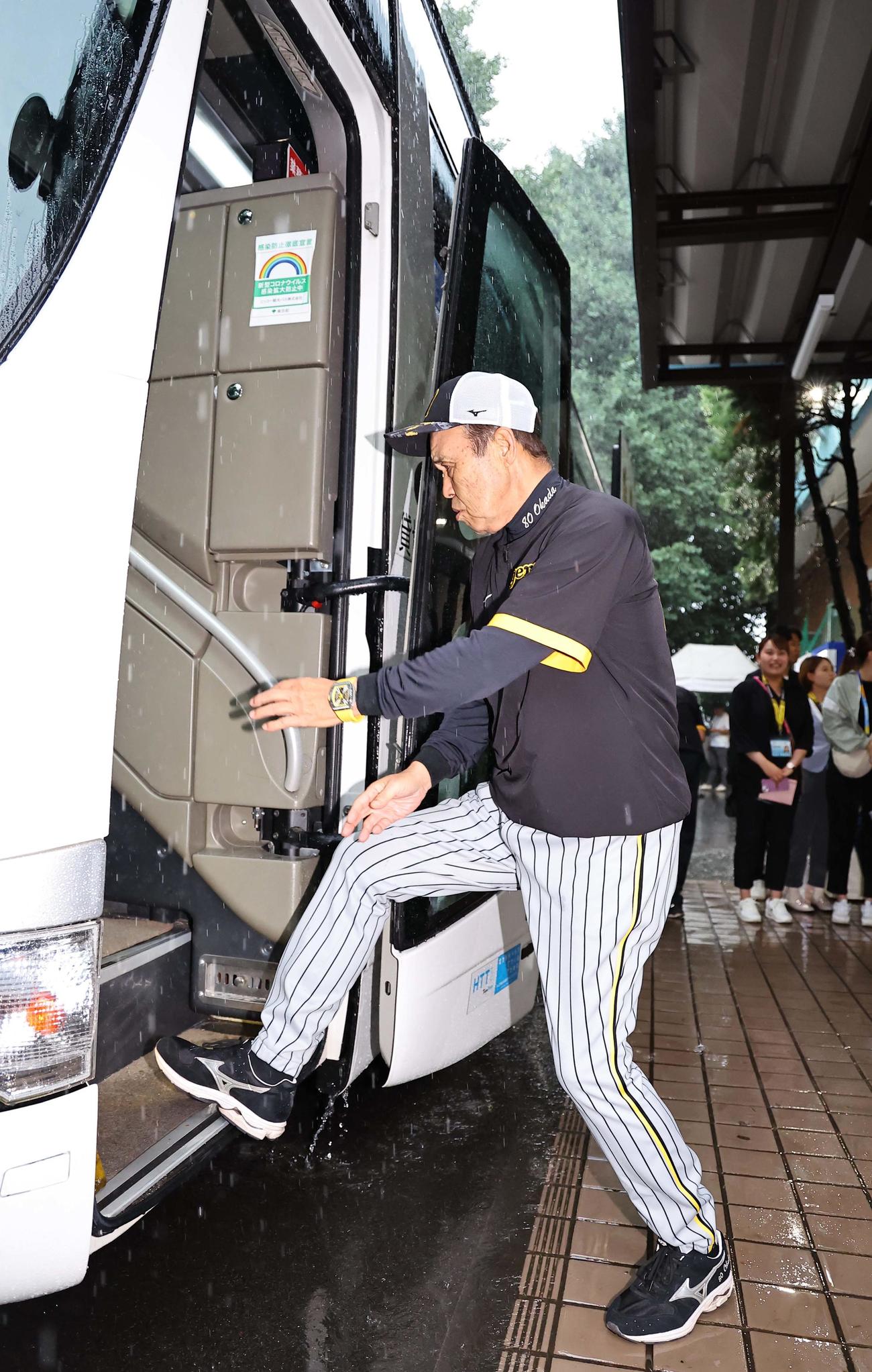 雨の中、足早にバスに乗り込む岡田監督（撮影・上田博志）