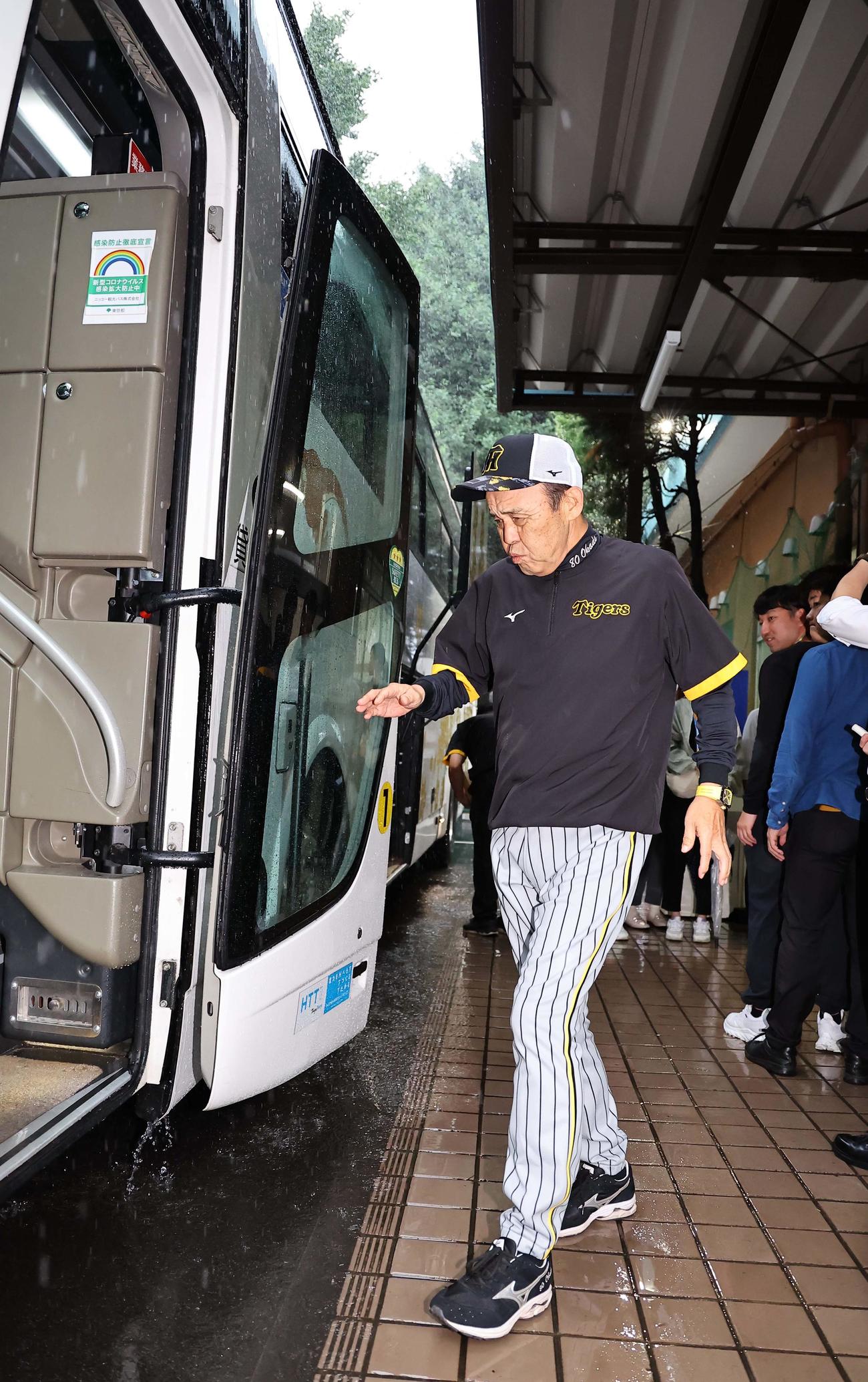 雨の中、足早にバスに乗り込む岡田監督（撮影・上田博志）