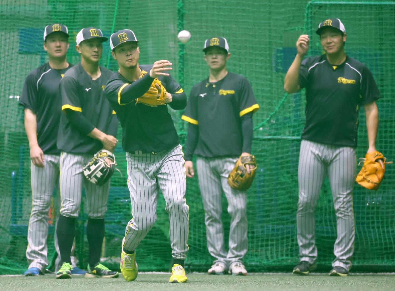 佐藤輝（中央）は内野陣と守備練習をする（撮影・上田博志）
