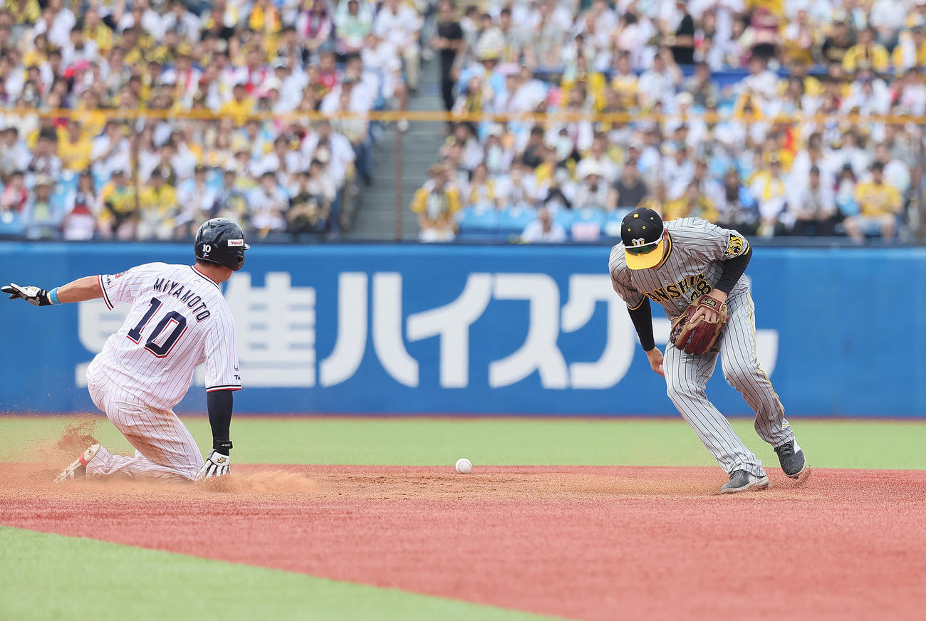 ヤクルト対阪神　3回裏ヤクルト1死一塁、オスナの二ゴロの送球を捕球しそこねる遊撃手小幡（右）。一塁走者宮本（撮影・足立雅史）