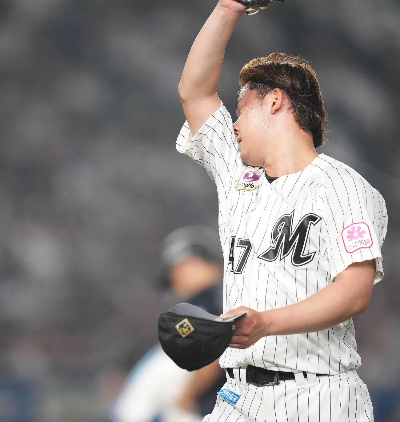 ロッテ対オリックス　10回表を終え、汗をぬぐいながらベンチへ戻るロッテ鈴木（撮影・鈴木みどり）