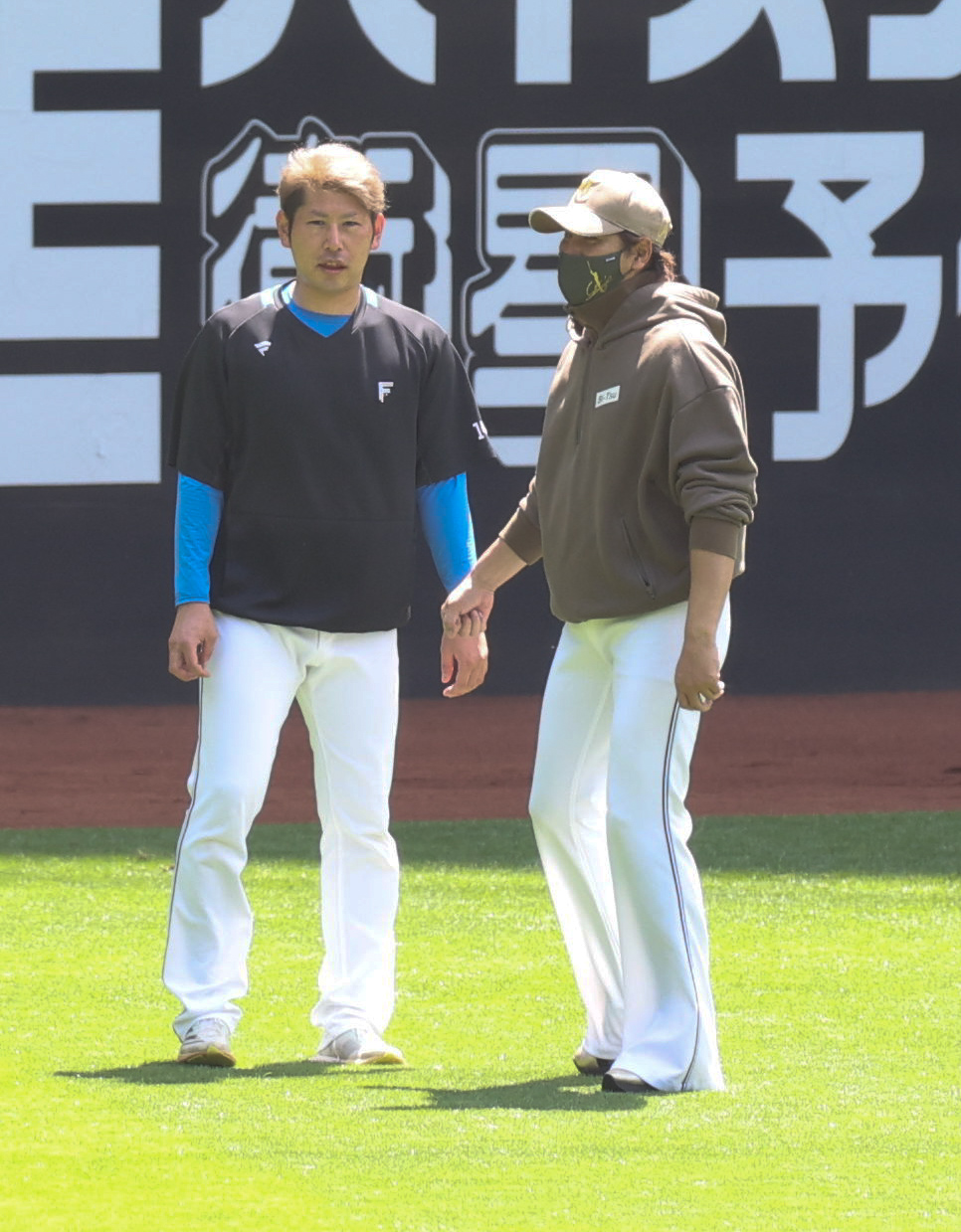 日本ハム対ソフトバンク　試合前、会話する日本ハム加藤貴（左）と新庄監督（撮影・佐藤翔太）