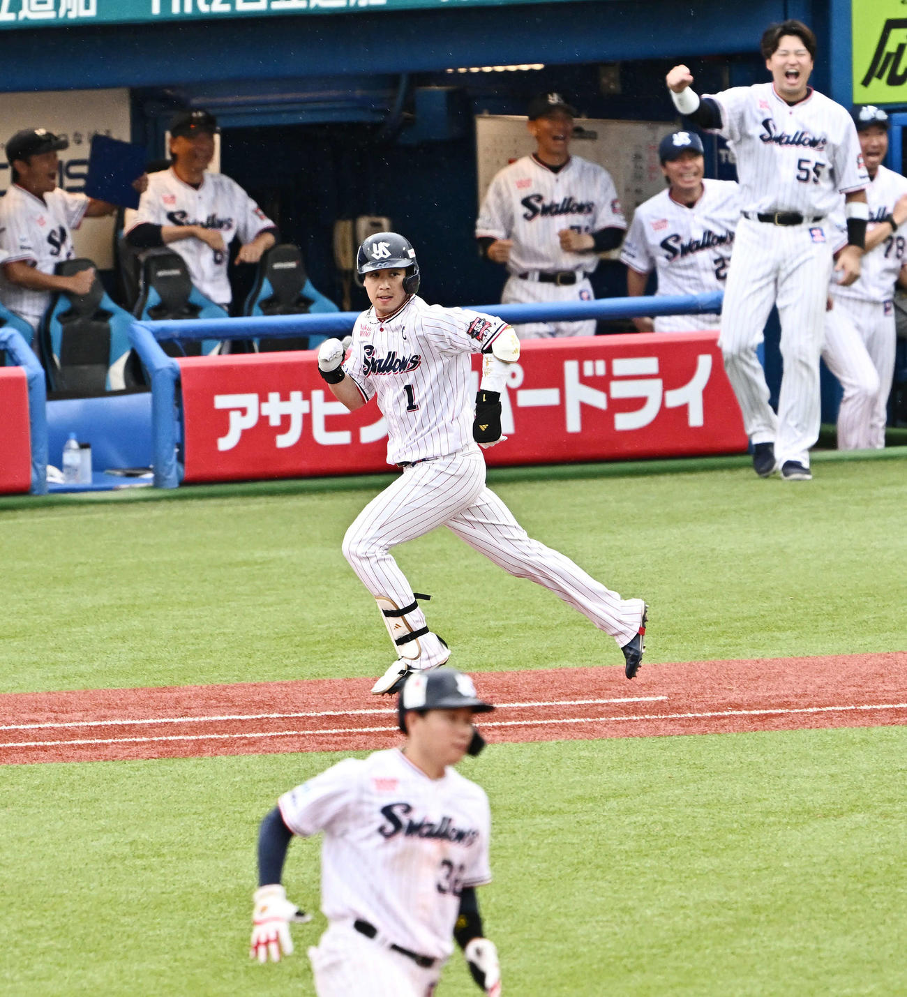 ヤクルト対阪神　8回裏ヤクルト2死一、三塁、代打山田（中央）は左翼に適時打を放ち盛り上がるベンチの前を走る（撮影・滝沢徹郎）　