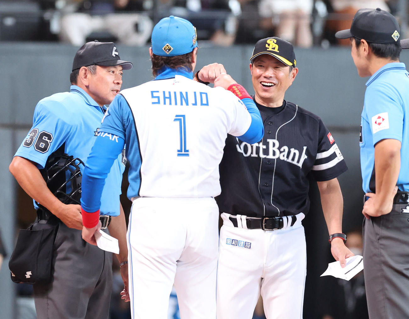 日本ハム対ソフトバンク　試合前、グータッチをする日本ハム新庄監督（左手前）と小久保監督（撮影・佐藤翔太）