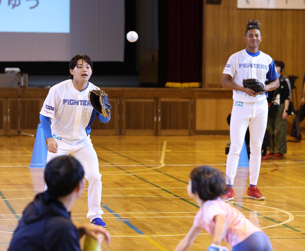 札幌市内の小学校を訪問した日本ハム田宮（左）と水谷は子どもたちとキャッチボールする（撮影・黒川智章）