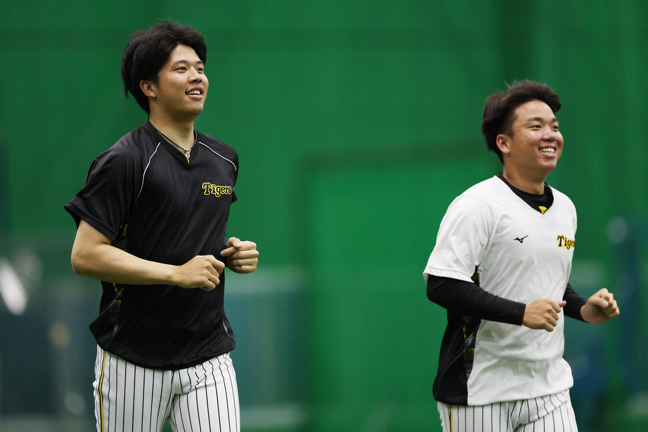 笑顔でランニングする阪神才木（左）と村上（撮影・前田充）