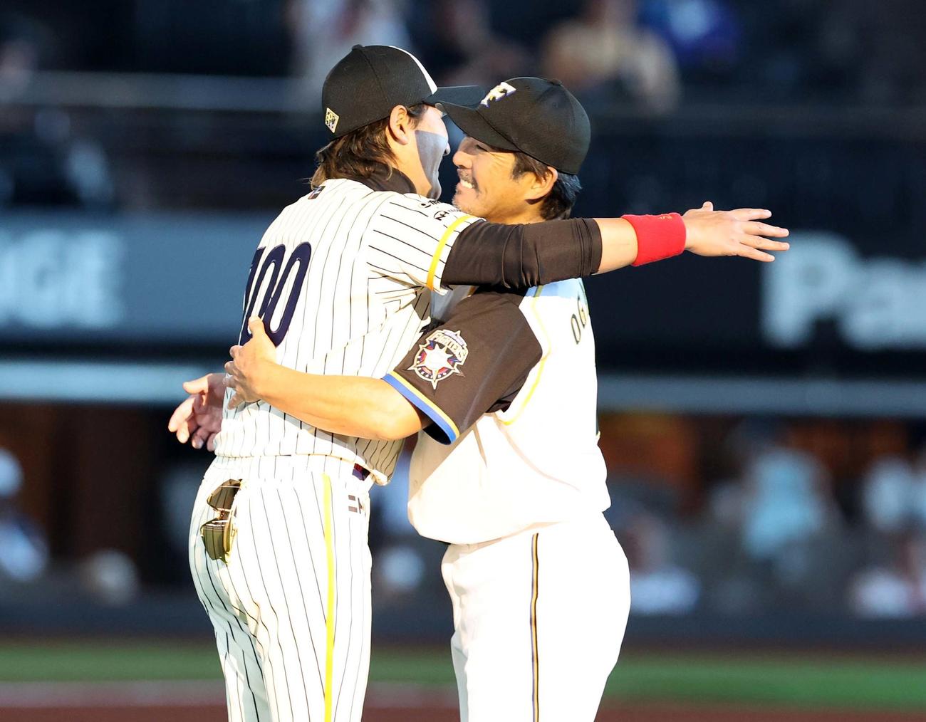 日本ハム対ロッテ　50周年セレモニーで小笠原氏と抱き合う新庄監督（撮影・黒川智章）