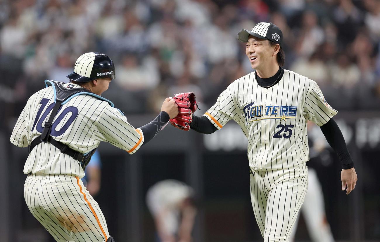 日本ハム対ロッテ　7回表、打者を3人で抑え田宮とタッチする宮西（撮影・黒川智章）