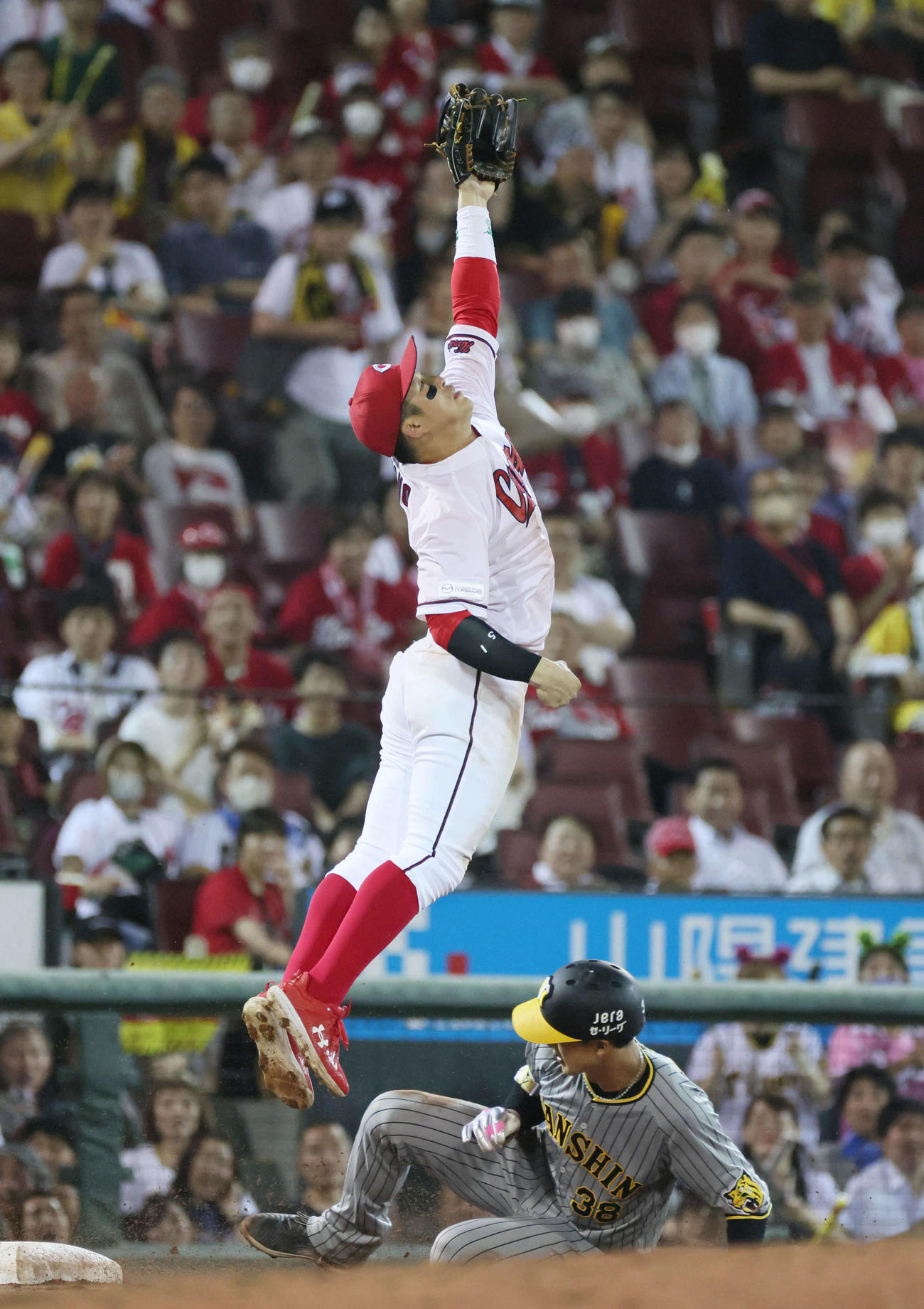広島対阪神　10回表阪神1死一塁、島田の右前打で野間が三塁に悪送球、捕れない小園。下は滑り込んだ小幡（撮影・加藤孝規）