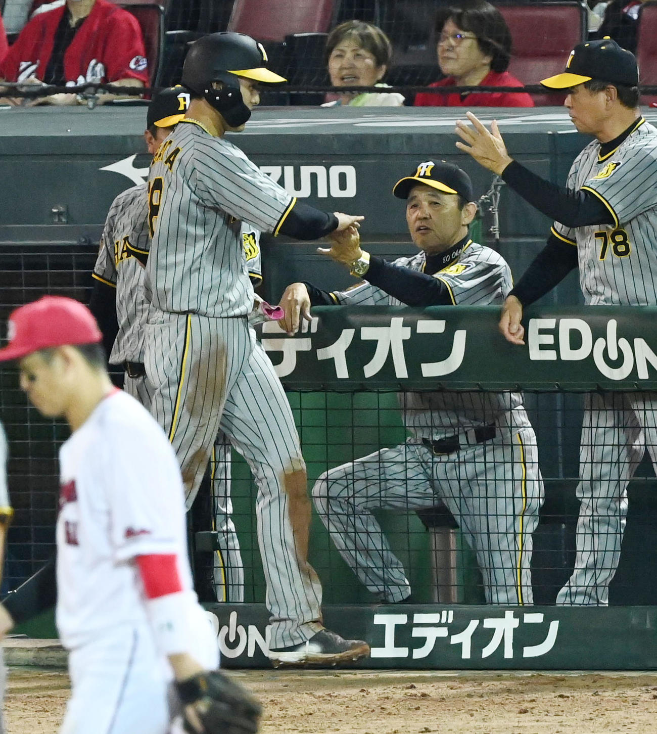 広島対阪神　10回表阪神1死一塁、島田の右前打と悪送球で生還した小幡（左）を迎える岡田監督（撮影・前岡正明）