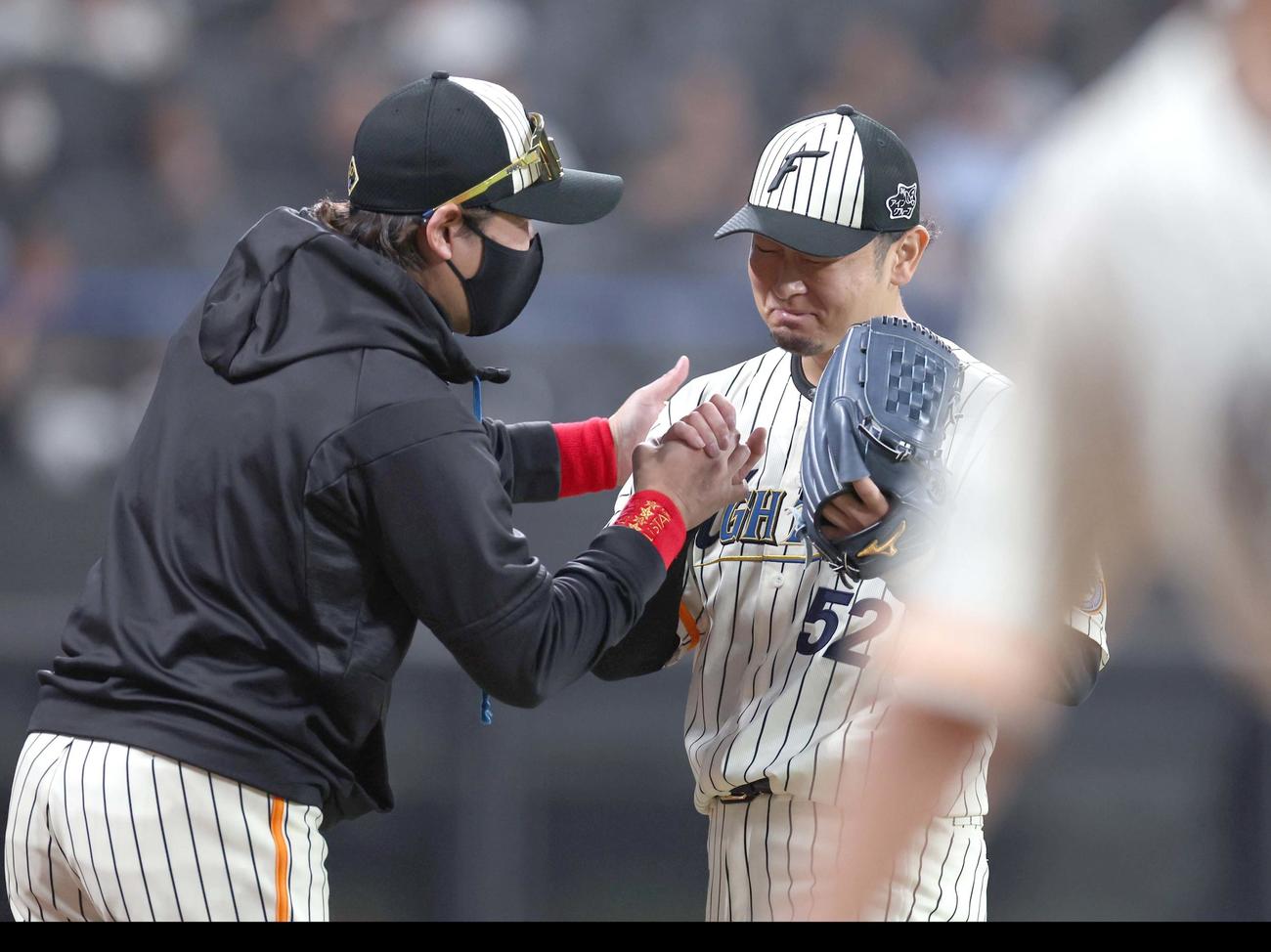 日本ハム対ロッテ　8回に登板し打者を3人で抑えた日本ハム池田（右）は新庄監督に出迎えられ感極まる（撮影・黒川智章）