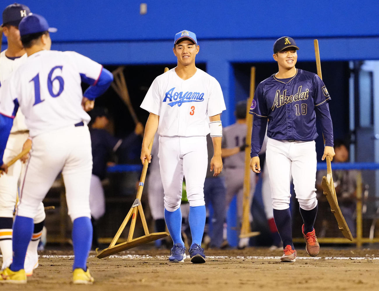 2024年6月22日、グラウンド整備する愛工大・中村優斗（右）と青学大・西川史礁ら