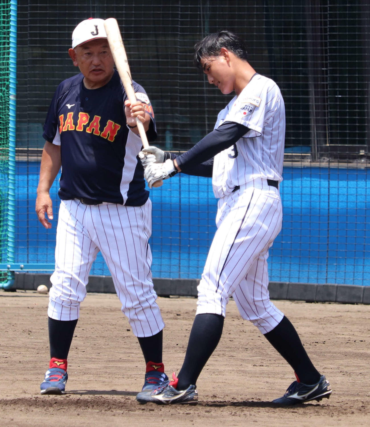 侍ジャパン大学代表選手選考合宿、最終日。青学大・西川に付き切りで指導をする堀井監督（撮影・保坂淑子）