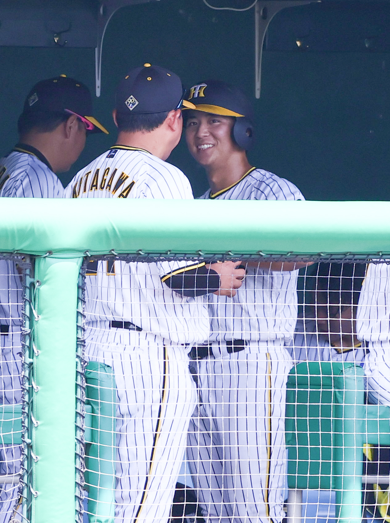 ウエスタン・リーグ阪神対中日　2回裏に三塁適時内野安打を放った阪神井坪（右）は3回の守備に向かう前にベンチで笑顔を見せる（撮影・上山淳一）