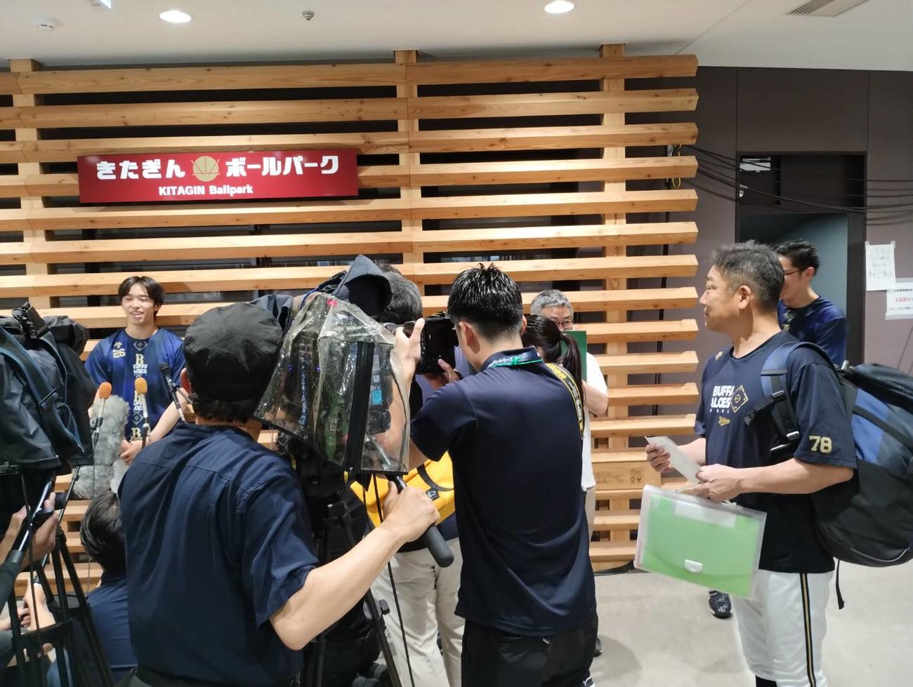 盛岡での地元凱旋（がいせん）登板が中止となったオリックス斎藤の取材を、通りがかった中嶋監督（右）が興味深そうにのぞき込む（撮影・大池和幸）
